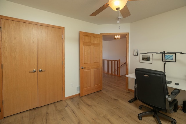 office featuring a ceiling fan, light wood-type flooring, and baseboards
