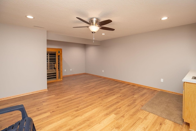 unfurnished room with light wood-style flooring, a ceiling fan, baseboards, recessed lighting, and a textured ceiling