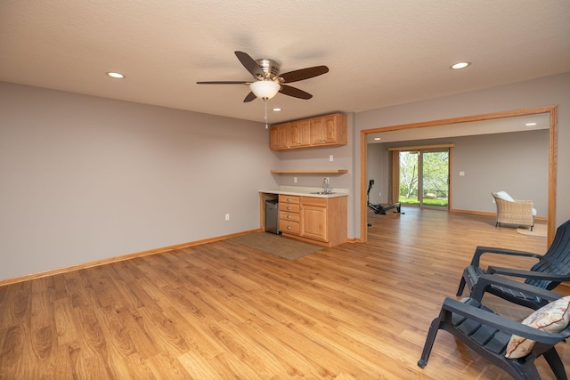 kitchen featuring light wood finished floors, recessed lighting, light countertops, baseboards, and ceiling fan