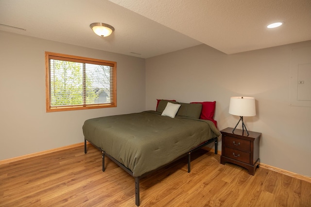 bedroom with baseboards, light wood-type flooring, and recessed lighting