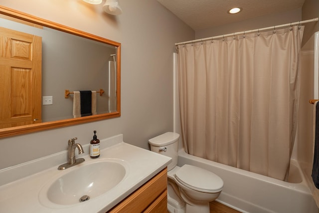 full bath featuring toilet, vanity, shower / bath combo with shower curtain, a textured ceiling, and recessed lighting