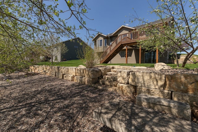 rear view of house featuring stairway and a wooden deck