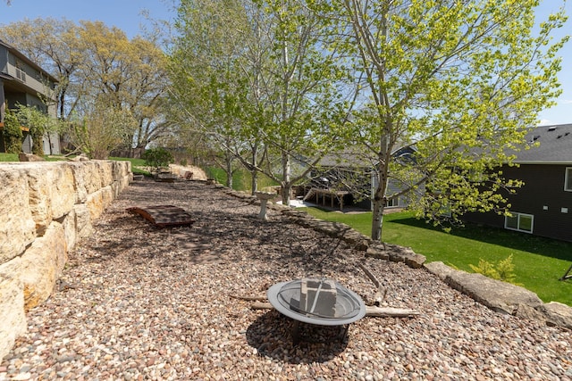 view of green lawn featuring a fire pit