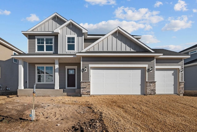 craftsman-style house featuring board and batten siding, a porch, stone siding, an attached garage, and driveway