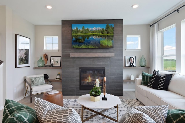 living area featuring wood finished floors, recessed lighting, baseboards, and a fireplace