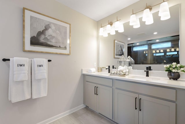 full bath with walk in shower, double vanity, and baseboards