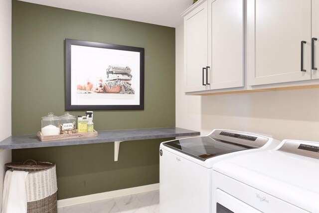 clothes washing area featuring cabinet space, independent washer and dryer, and marble look tiles