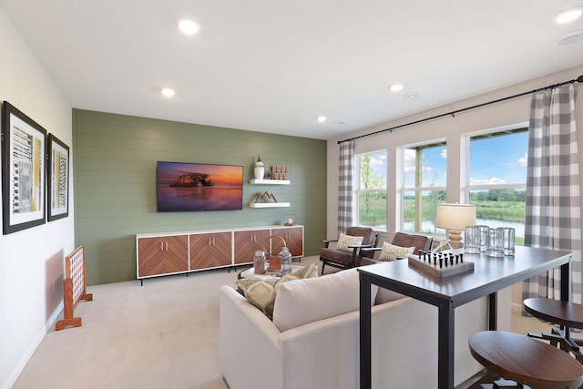 living room with wooden walls, light carpet, recessed lighting, and baseboards