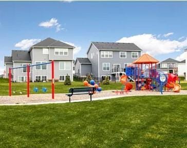 back of property featuring playground community, a residential view, and a lawn