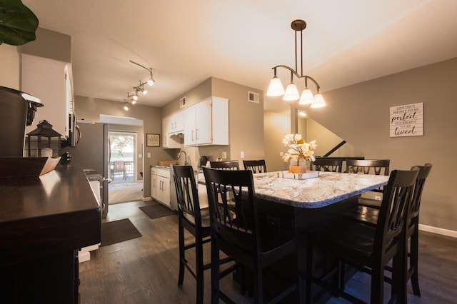 2520 Le Homme Dieu Hts NE Unit 2, Alexandria Twp, MN 56308 - dining room featuring dark wood-style floors, a chandelier, and baseboards