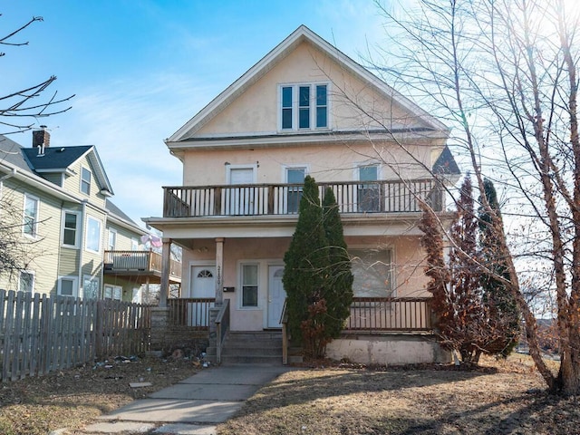 2100 Dupont Ave N, Minneapolis, MN 55411 - view of front of property with a balcony, stucco siding, and covered porch