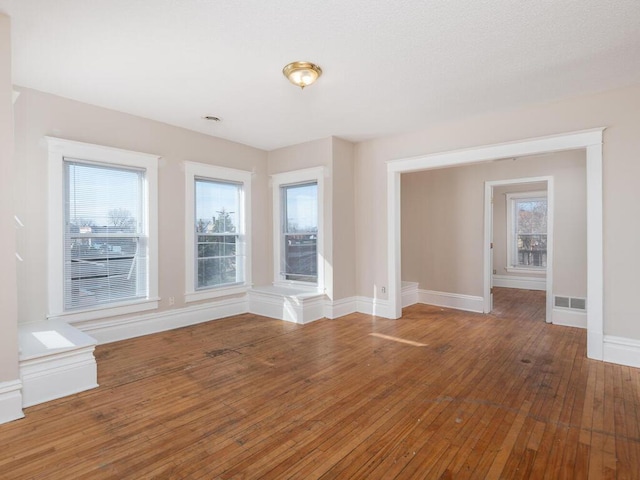 2100 Dupont Ave N, Minneapolis, MN 55411 - unfurnished room featuring plenty of natural light, baseboards, and hardwood / wood-style floors