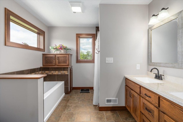 1704 156th St, Erin Prairie Twp, WI 54017 - full bathroom featuring healthy amount of natural light, double vanity, a garden tub, and stone finish floors