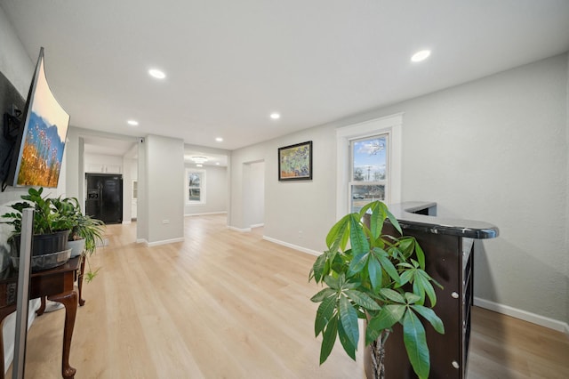 living area featuring light wood-style flooring, baseboards, and recessed lighting