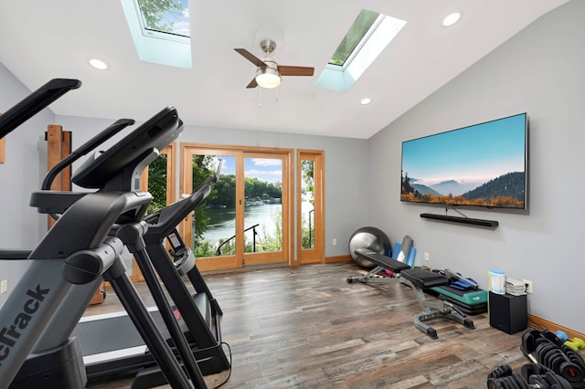 exercise room featuring a skylight, lofted ceiling, wood finished floors, recessed lighting, and baseboards