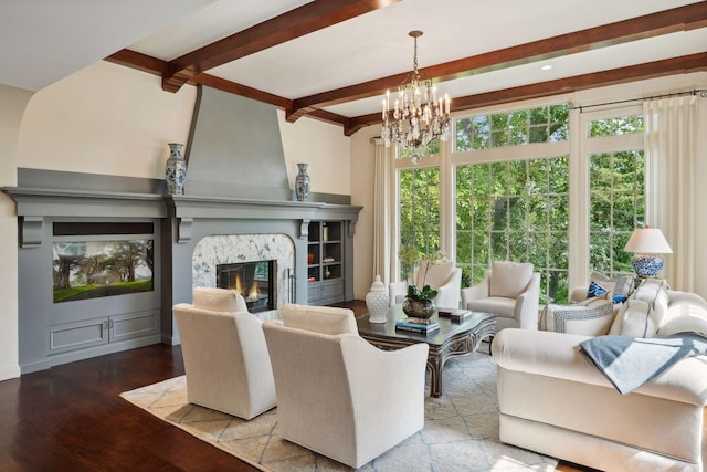 living area with a high end fireplace, beam ceiling, wood finished floors, and a chandelier