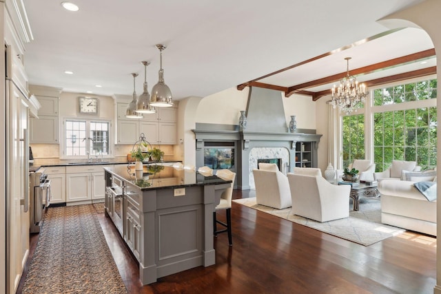 kitchen featuring open floor plan, tasteful backsplash, a chandelier, a breakfast bar, and recessed lighting