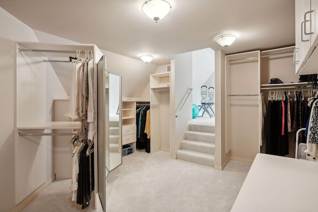 walk in closet featuring light colored carpet