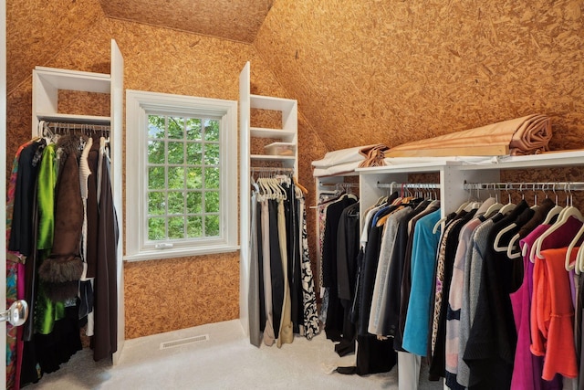 spacious closet featuring lofted ceiling and carpet flooring
