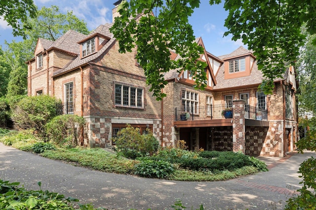 view of front of home with brick siding, a balcony, and a garage