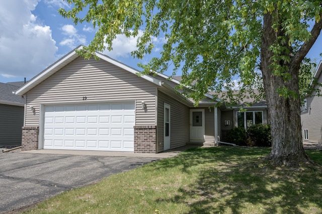 ranch-style house with brick siding, an attached garage, a front yard, and asphalt driveway