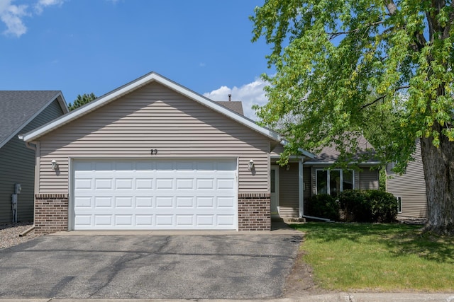 ranch-style house with brick siding, driveway, an attached garage, and a front lawn