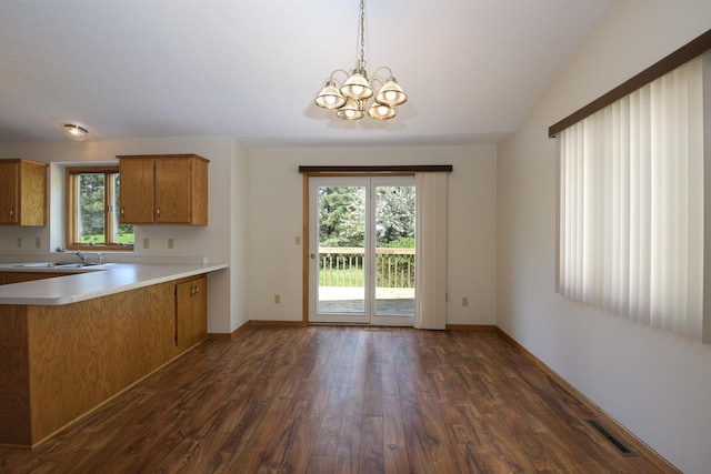 kitchen featuring a sink, dark wood finished floors, brown cabinets, and light countertops