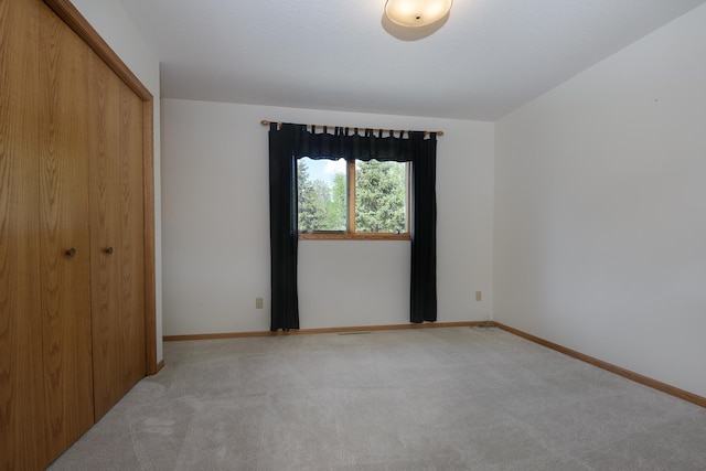 unfurnished bedroom with carpet flooring, a closet, and baseboards