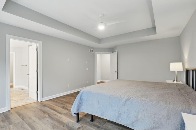 1088 Pine Hill Ln, White Bear Lake, MN 55127 - bedroom with wood finished floors, a raised ceiling, baseboards, ensuite bathroom, and ceiling fan