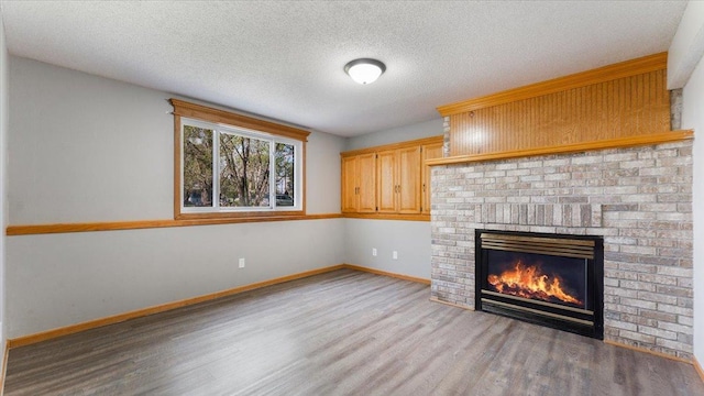 2070 Prospect Dr NE, Saint Cloud, MN 56304 - unfurnished living room featuring wood finished floors, a fireplace, baseboards, and a textured ceiling