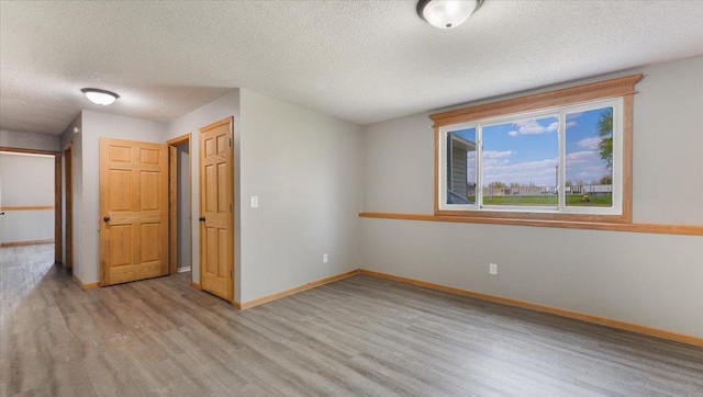 2070 Prospect Dr NE, Saint Cloud, MN 56304 - empty room featuring light wood finished floors, a textured ceiling, and baseboards
