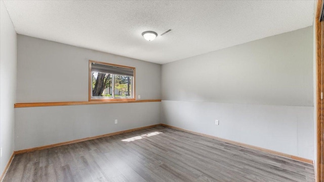 2070 Prospect Dr NE, Saint Cloud, MN 56304 - spare room featuring wood finished floors, baseboards, and a textured ceiling