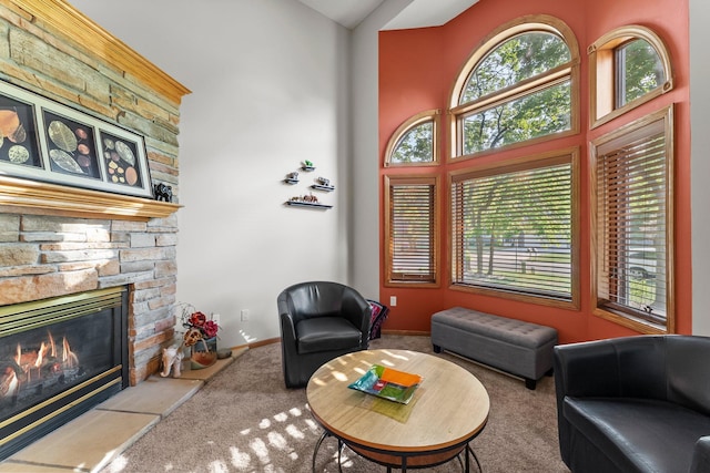 13367 Martin St NW, Andover, MN 55304 - living area featuring carpet, a stone fireplace, a towering ceiling, and baseboards