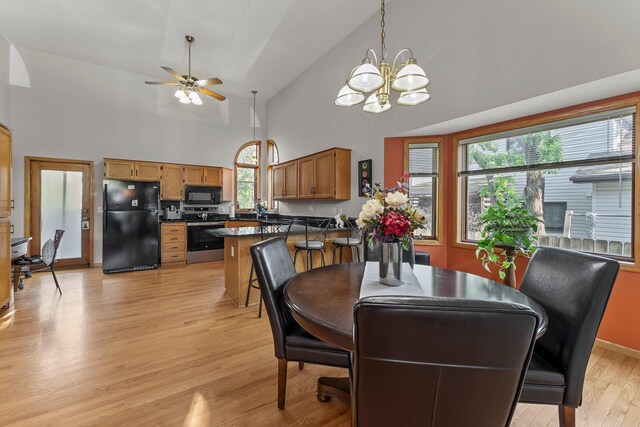 13367 Martin St NW, Andover, MN 55304 - dining space featuring light wood-style floors, high vaulted ceiling, ceiling fan, a chandelier, and baseboards