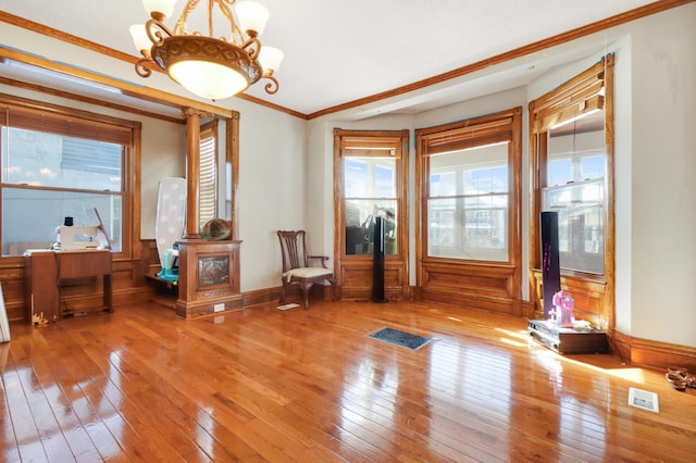 sitting room featuring hardwood / wood-style flooring, a chandelier, ornamental molding, and baseboards
