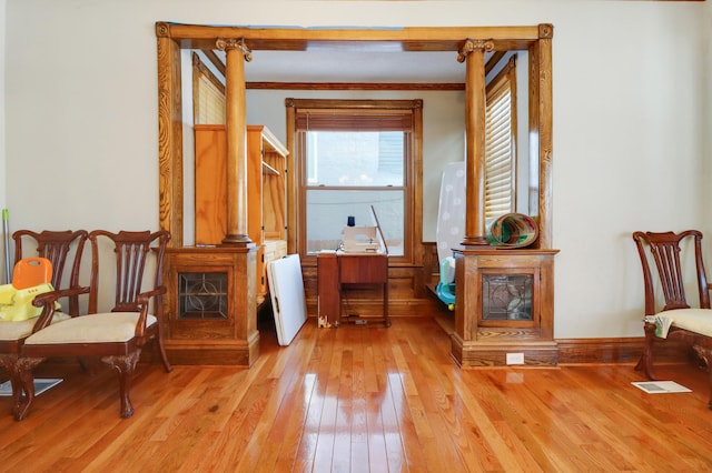 corridor with light wood-style floors and ornamental molding