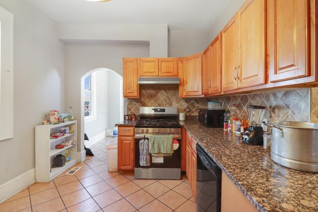 kitchen with black appliances, arched walkways, tasteful backsplash, under cabinet range hood, and baseboards