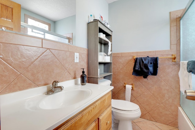 full bath with tile walls, toilet, vanity, and tile patterned flooring