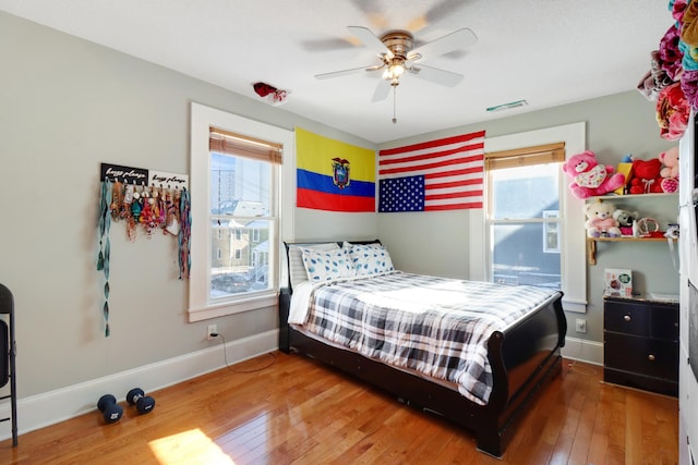 bedroom with hardwood / wood-style floors, baseboards, and a ceiling fan