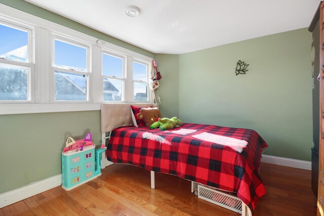 bedroom with baseboards and wood finished floors