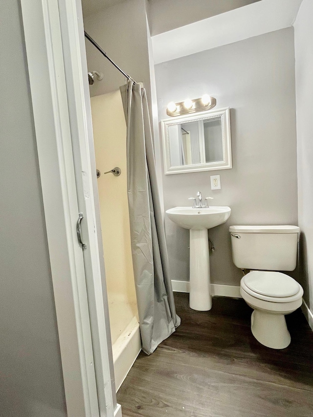 full bathroom with a shower with curtain, toilet, wood finished floors, and baseboards