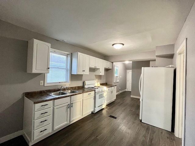 kitchen with white appliances, a sink, dark countertops, dark wood-style floors, and baseboards