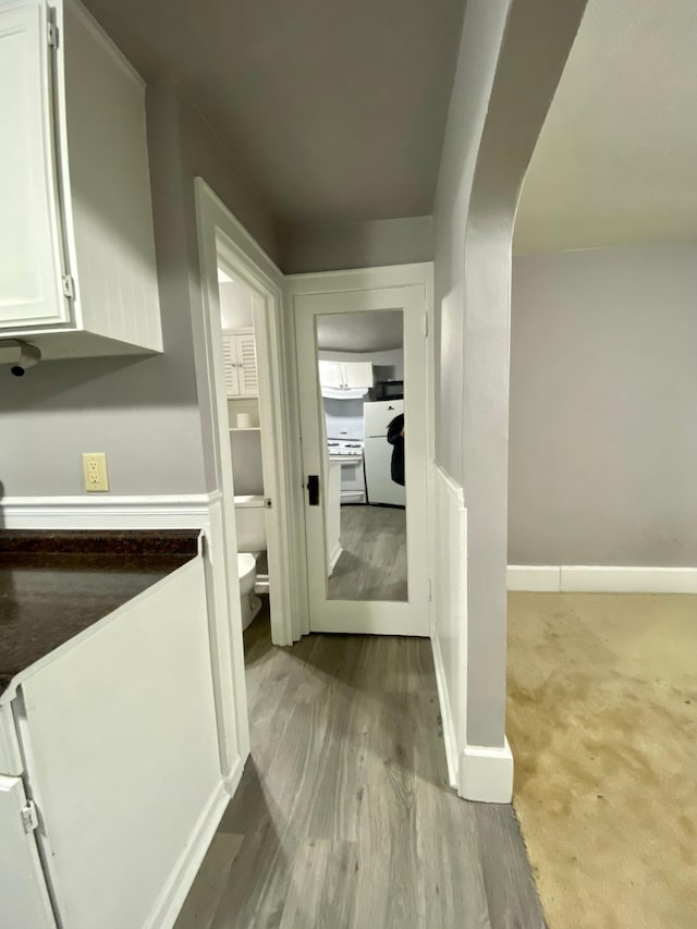 hall with baseboards and wood finished floors