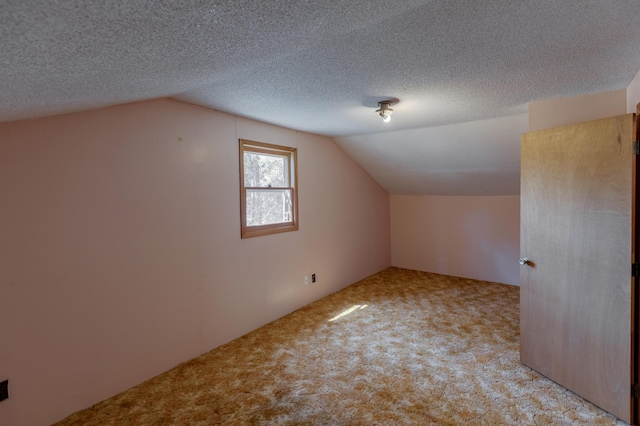 bonus room featuring carpet, lofted ceiling, and a textured ceiling
