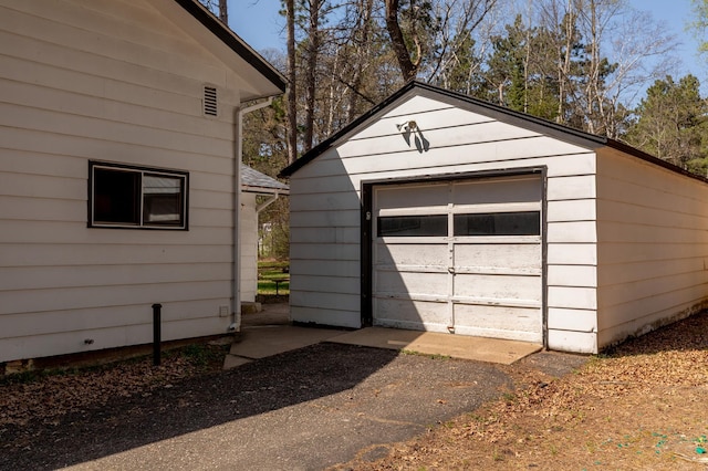 detached garage featuring asphalt driveway
