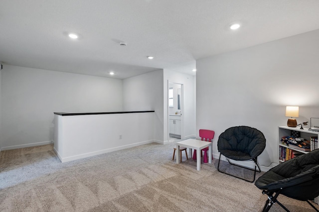 living area with carpet flooring, recessed lighting, baseboards, and an upstairs landing