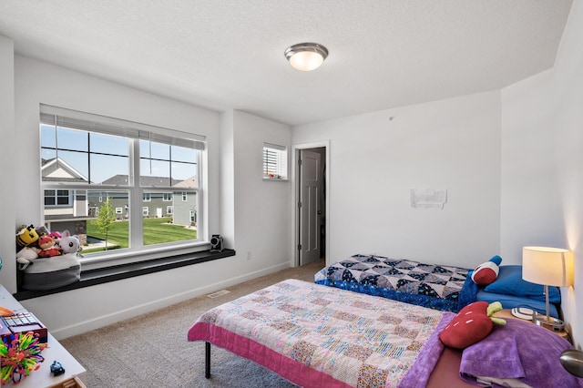 bedroom with carpet flooring, baseboards, and a textured ceiling