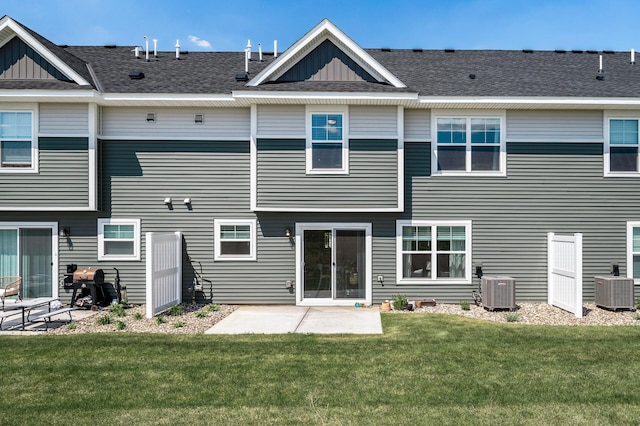 back of house featuring board and batten siding, a yard, cooling unit, and a patio area