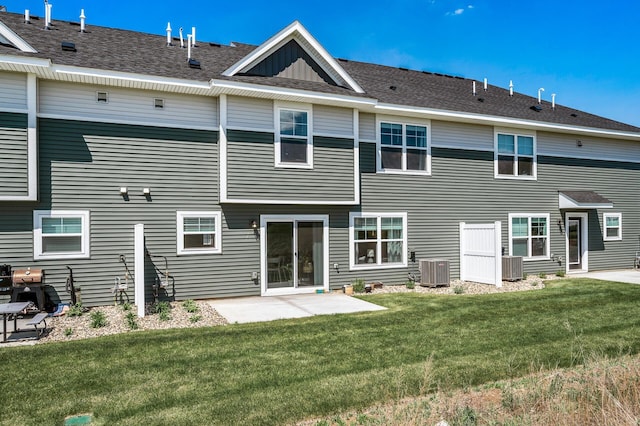 rear view of house with central AC unit, a yard, and a patio