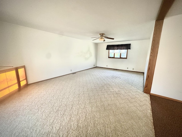 spare room featuring carpet flooring, ceiling fan, and baseboards